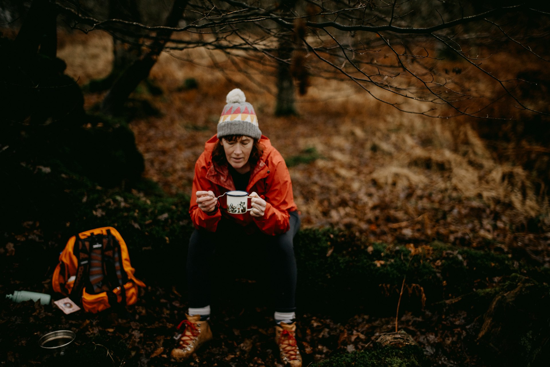 a person sitting on the ground with a cup of coffee
